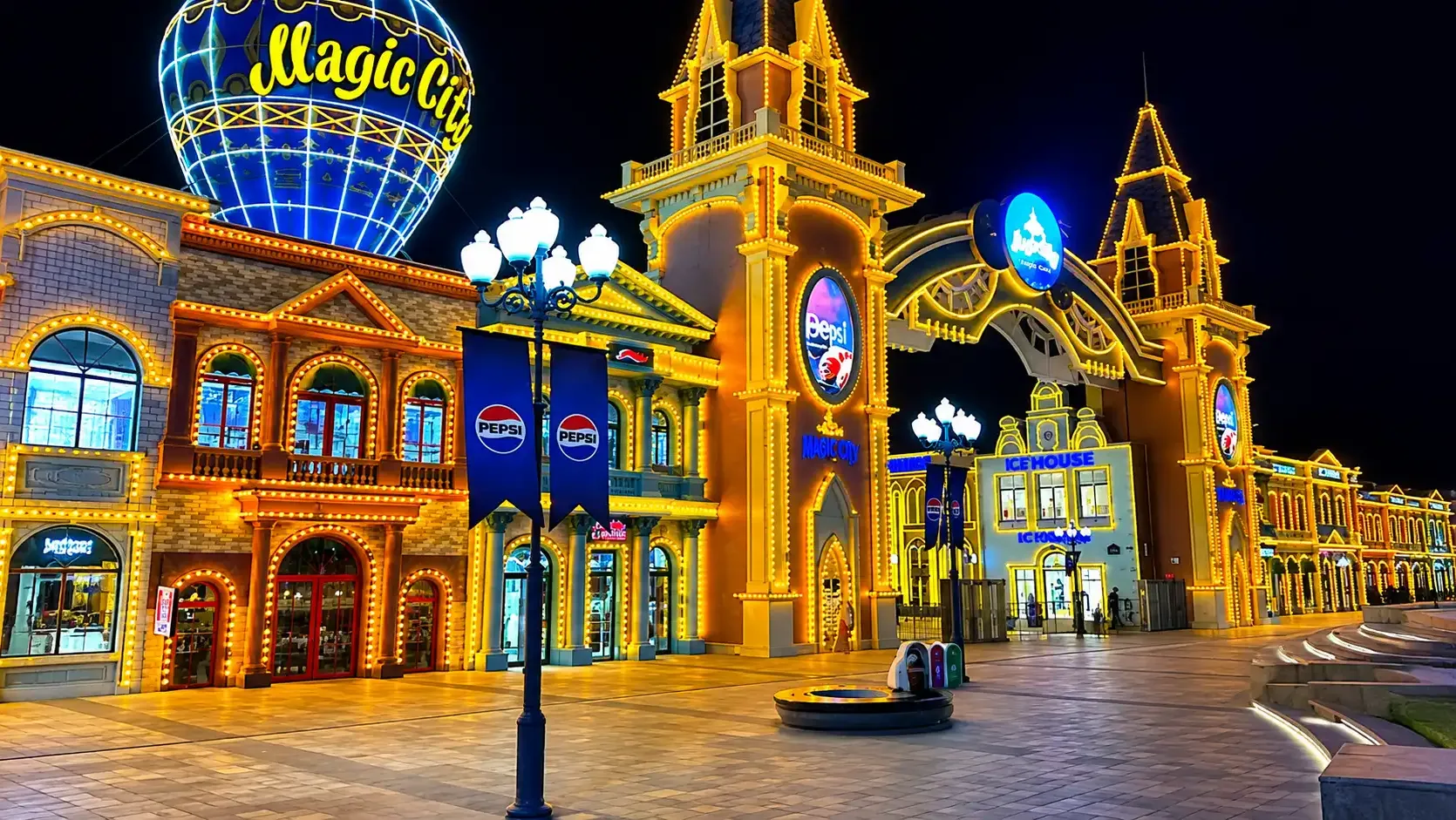 The Magic City promenade and its balloon landmark under evening lights.